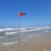 Guarda-vidas marcam locais perigosos  com bandeira vermelha no mar em Rincão