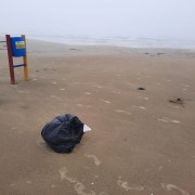 Sacos de lixo e sujeira espalhados na beira-mar de Balneário Rincão